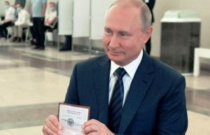 Presiden Rusia Vladimir Putin menunjukkan paspornya kepada petugas pemungutan suara saat tiba di tempat pemungutan suara di Moskow, Rusia, 1 Juli 2020