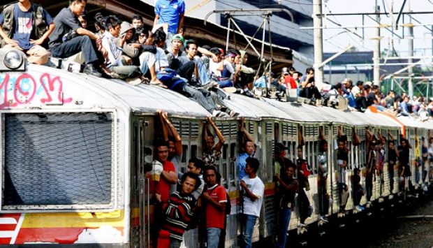 Penumpang kereta bergelantungan di pintu dan atap gerbong (Sumber: tempo.co, 2011)