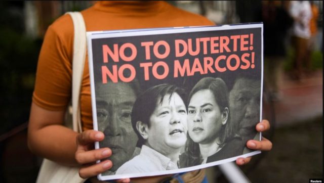 Seorang demonstran memegang poster saat protes pencalonan presiden Ferdinand “Bongbong” Marcos Jr., putra mendiang diktator Ferdinand Marcos, di Komisi Hak Asasi Manusia, di Kota Quezon, Metro Manila, Filipina. (Foto: Reuters)