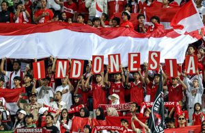 Suporter Indonesia memberi dukungan saat Timnas Indonesia bermain di Piala Asia U-23 2024 di Abdullah bin Khalifa Stadium, Doha, Qatar, Foto: AFP/Karim Jaafar