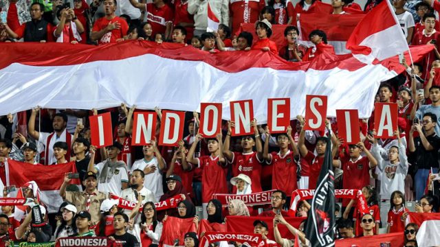 Suporter Indonesia memberi dukungan saat Timnas Indonesia bermain di Piala Asia U-23 2024 di Abdullah bin Khalifa Stadium, Doha, Qatar, Foto: AFP/Karim Jaafar