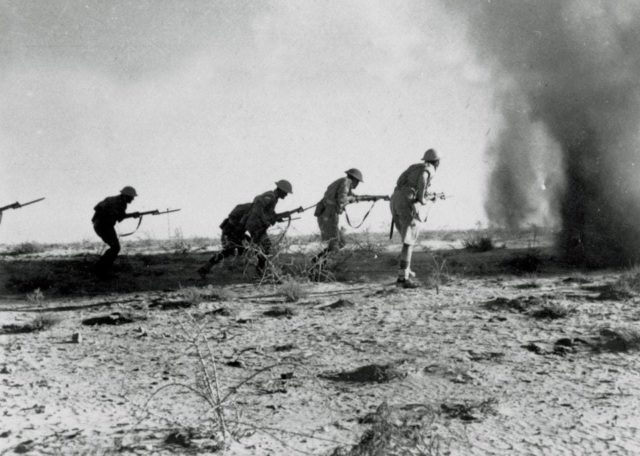 Tentara Inggris bergerak maju dengan senapan yang dipasangi bayonet dalam Pertempuran El Alamein Kedua di tahun 1942. (Sumber: National Army Museum)