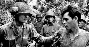 Seorang tersangka anggota Vietcong (kanan) ditangkap oleh tentara ARNV pada tahun 1965 selama Perang Vietnam. (Sumber: alphahistory.com)