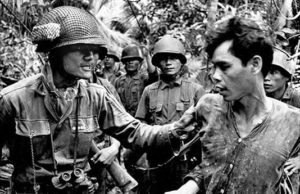 Seorang tersangka anggota Vietcong (kanan) ditangkap oleh tentara ARNV pada tahun 1965 selama Perang Vietnam. (Sumber: alphahistory.com)