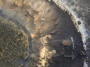 Sebuah dataran tinggi yang kaya lempung di cekungan Hellas di Mars. Warna biru di dekat tepinya adalah lempung yang mengandung aluminium. Warna merah-oranye di bawahnya adalah lempung yang mengandung besi dan magnesium. Gambar tersebut menangkap area seluas 1 kilometer. (Sumber: Phys.org)