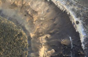 Sebuah dataran tinggi yang kaya lempung di cekungan Hellas di Mars. Warna biru di dekat tepinya adalah lempung yang mengandung aluminium. Warna merah-oranye di bawahnya adalah lempung yang mengandung besi dan magnesium. Gambar tersebut menangkap area seluas 1 kilometer. (Sumber: Phys.org)