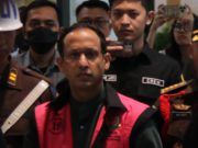 Nadiem Makarim mengenakan rompi pink Kejagung saat digelandang ke mobil tahanan Kejagung. (foto: Sulindo/Iqyanut Taufik)